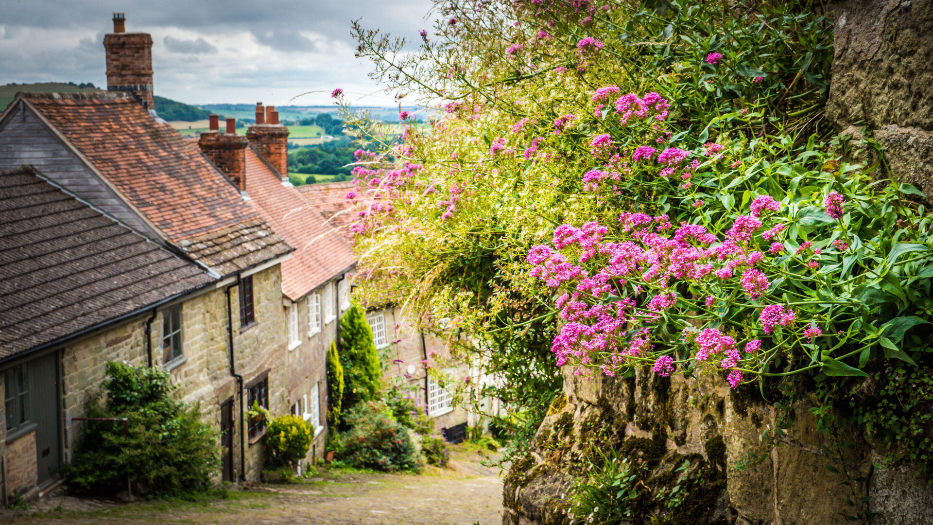 Old cobbled street in Shaftesbury, UK with flowers
